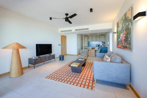 a living room with a couch and a tv at Legend Hill Resort and Spa in Rivière Noire