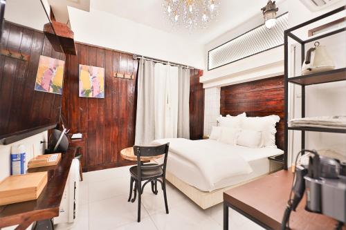 a bedroom with a bed and a desk and a chair at Daegu February Hotel Hwanggeum in Daegu