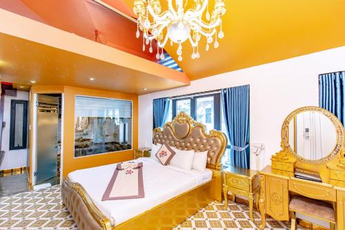 a bedroom with a king sized bed and a chandelier at Dallas Hotel Dalat in Da Lat