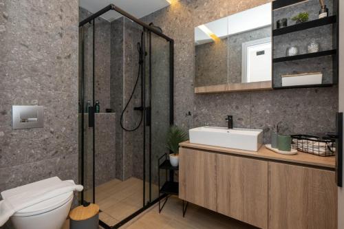 a bathroom with a shower and a toilet and a sink at 8 Blocks Apartments in Alexandroupoli