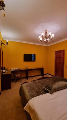 a bedroom with a bed and a desk and a tv at Grandview Boutique Hotel in Baku