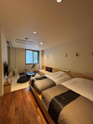 a bedroom with two beds and a living room at Niseko Konbu Onsen Tsuruga Moku-no-sho in Niseko