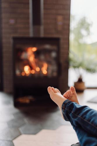 a person with their feet up in front of a fireplace at CzillChata - dom z balią in Maków Podhalański