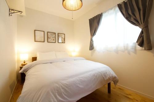 a bedroom with a white bed and a window at Sole ONNA in Inbu