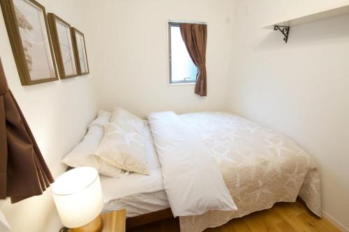 a bedroom with a bed with white sheets and a window at Sole ONNA in Inbu
