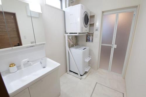 a white bathroom with a sink and a shower at Sole ONNA in Inbu