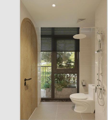 a bathroom with a toilet and a window at Grand Central Hotel- Vinhomes Ocean Park 3 in Ðình Loan