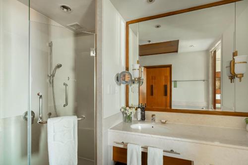 a bathroom with a sink and a shower and a mirror at Shangri-La Chiang Mai in Chiang Mai