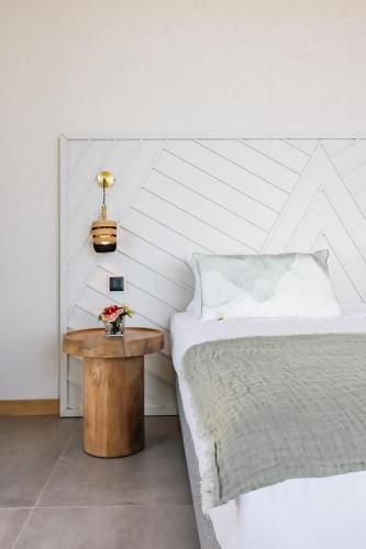 a bedroom with a bed and a table with flowers on it at Legend Hill Resort and Spa in Rivière Noire