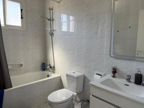 a bathroom with a toilet and a tub and a sink at Central 2 Bedroom Apartment Pafia 2 in Paphos City