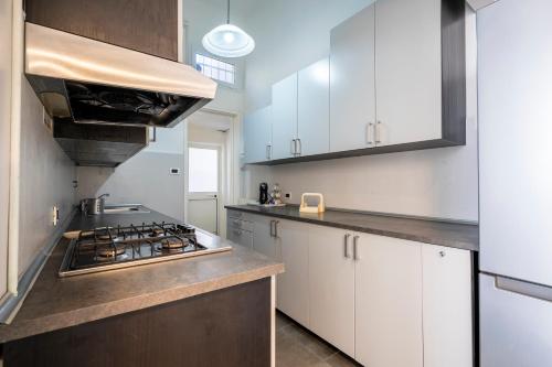 a kitchen with white cabinets and a stove top oven at Appartamento Luxury vista mare in Lido di Camaiore