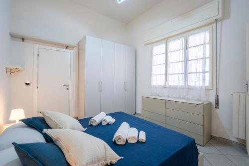 a bedroom with a blue bed with slippers on it at Appartamento Luxury vista mare in Lido di Camaiore
