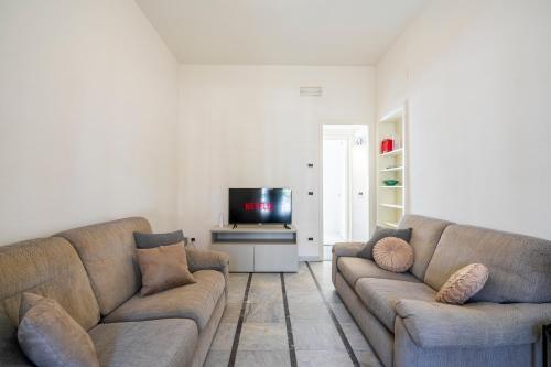 a living room with two couches and a tv at Appartamento Luxury vista mare in Lido di Camaiore