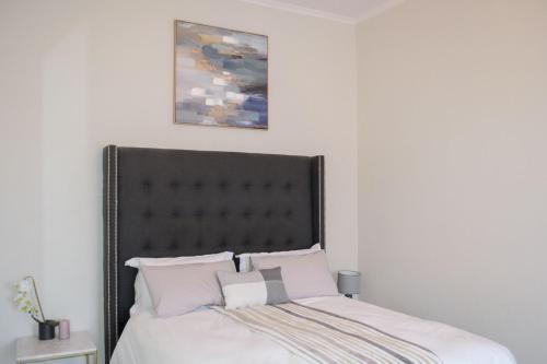 a bed with a black headboard in a bedroom at The View Apartment 1 in Lüderitz
