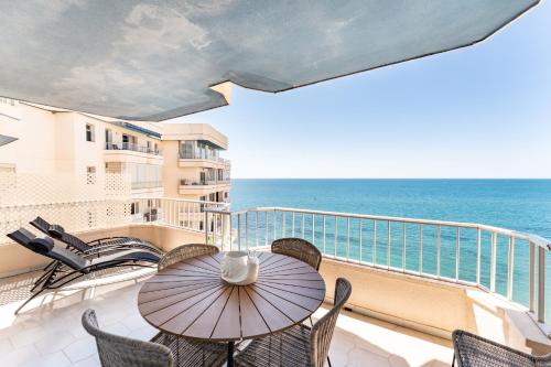 a balcony with a table and chairs and the ocean at Amazing Rey de España Views in Fuengirola