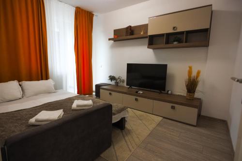 a bedroom with a bed and a flat screen tv at The Chic Loft QResidence in Iaşi