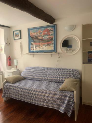 a bed in a bedroom with a painting on the wall at CASABARBARA lerici in Lerici