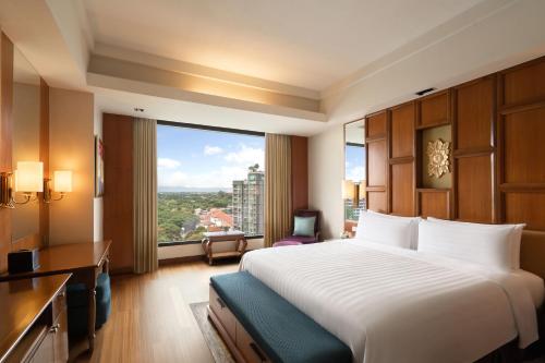 a hotel room with a large bed and a large window at Shangri-La Chiang Mai in Chiang Mai
