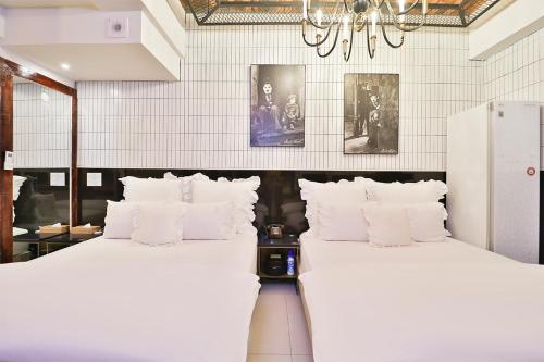 two beds with white pillows in a room at Daegu February Hotel Hwanggeum in Daegu