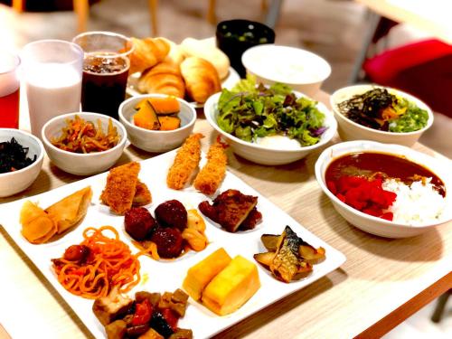 a table with a plate of food and bowls of food at APA Hotel Kagoshima Tenmonkan in Kagoshima