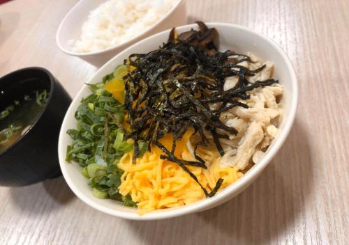 a bowl of food with noodles and vegetables on a table at APA Hotel Kagoshima Tenmonkan in Kagoshima