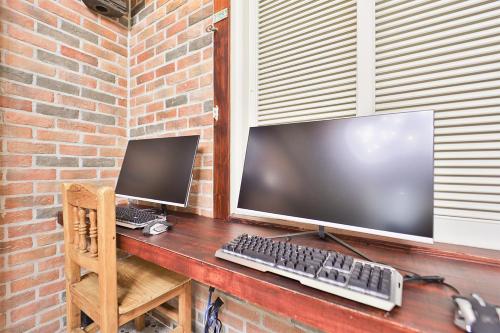 a desk with a computer monitor and a keyboard at Daegu February Hotel Hwanggeum in Daegu