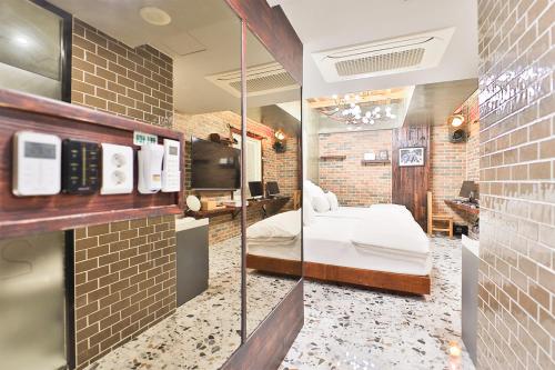 a room with a bed and a mirror at Daegu February Hotel Hwanggeum in Daegu
