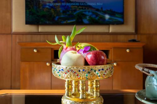 a bowl of fruits and vegetables on a table at Shangri-La Chiang Mai in Chiang Mai