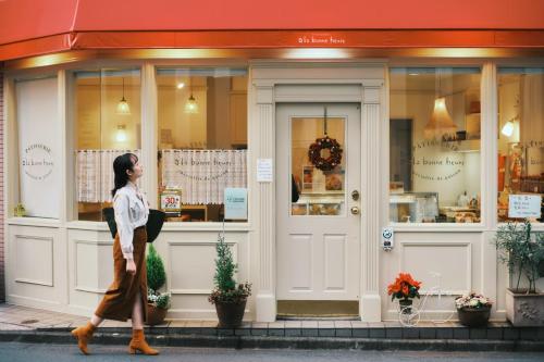 a woman walking down the street in front of a store at OMO3 Tokyo Akasaka by Hoshino Resort in Tokyo