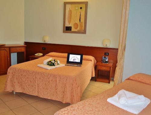 a room with two beds and a laptop on a table at Hotel San Marco in Francavilla al Mare