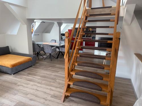 a wooden spiral staircase in a room with a couch at Ferienwohnung Vierjahreszeiten Herbst in Bad Langensalza