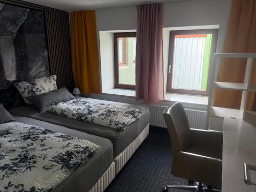 a hotel room with two beds and a chair at Ferienwohnung Vierjahreszeiten Herbst in Bad Langensalza