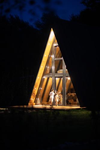 two people standing in the window of a house at night at A-Park Bologa in Bologa