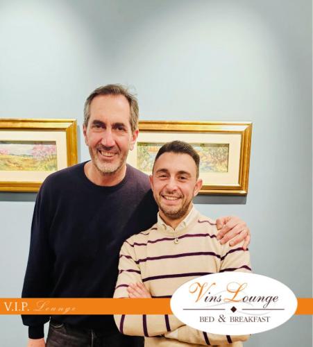 two men are posing for a picture with a ribbon at VinsLounge Suite in Barletta