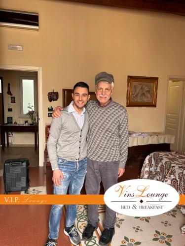 two men are posing for a picture in a room at VinsLounge Suite in Barletta