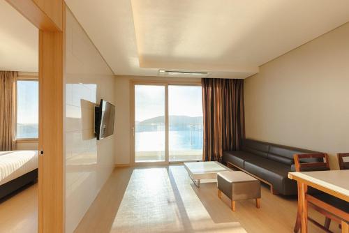 a hotel room with a bed and a couch at Sono Calm Geoje in Geoje 