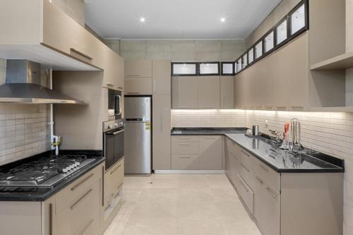 a large kitchen with stainless steel appliances and black counter tops at Gewan Palace New Alamein in El Alamein