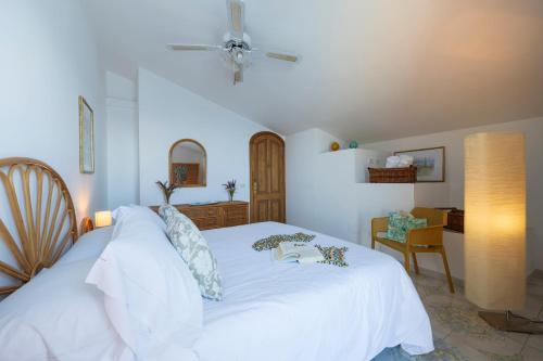 a bedroom with a white bed and a desk at Sea Whisper Home -Sunset, Sea, Easy Stay, Shops in Praiano