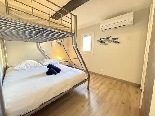 - une chambre avec des lits superposés avec un ours en peluche dans l'établissement Valras-Loc - Maison avec terrasse, parking, à Valras-Plage