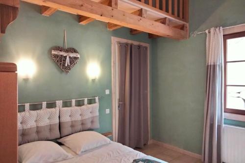 a bedroom with a bed with a heart on the wall at Gite le grenier du roc in Thiéfosse
