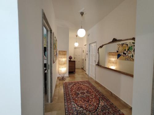 a hallway with a rug and a mirror on the wall at Corsica 23 - Affitti Brevi Italia in Gravina in Puglia