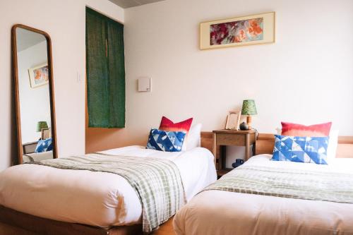 a bedroom with two beds and a mirror at Mi-HOTEL MIYA SHINJUKU in Tokyo