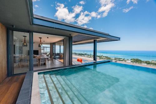 an infinity pool in a house with a view of the ocean at Legend Hill Resort and Spa in Rivière Noire