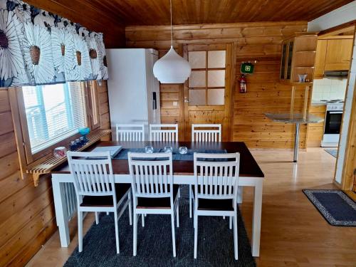 una cucina e una sala da pranzo con tavolo e sedie di Rauhan pesä a Karigasniemi