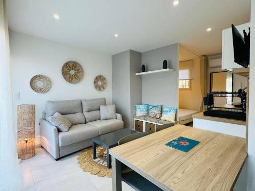 un salon avec une table et un canapé dans l'établissement Valras-Loc - Studio Moderne avec Jardin, à Valras-Plage