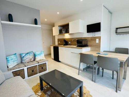 un salon avec une table et une cuisine dans l'établissement Valras-Loc - Studio Moderne avec Jardin, à Valras-Plage
