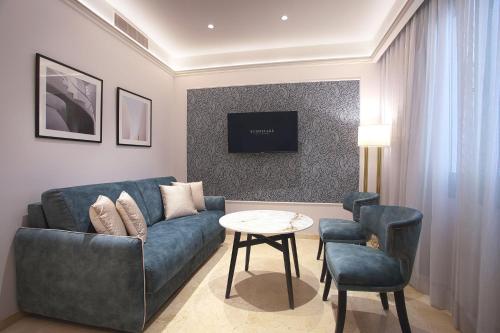 a living room with a blue couch and a table at Eurostars Laietana in Barcelona