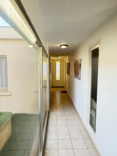 un couloir d'un bâtiment avec une porte jaune dans l'établissement Valras-Loc - Villa sur la plage, à Valras-Plage