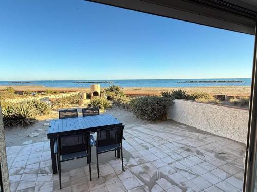 d'une terrasse avec une table et une vue sur la plage. dans l'établissement Valras-Loc - Villa sur la plage, à Valras-Plage