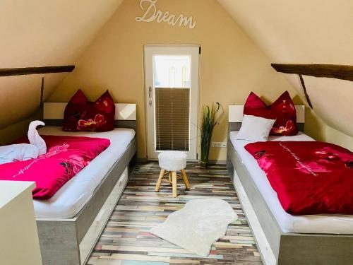 two beds in a room with red pillows on them at Casa del Sol in Schwaigern